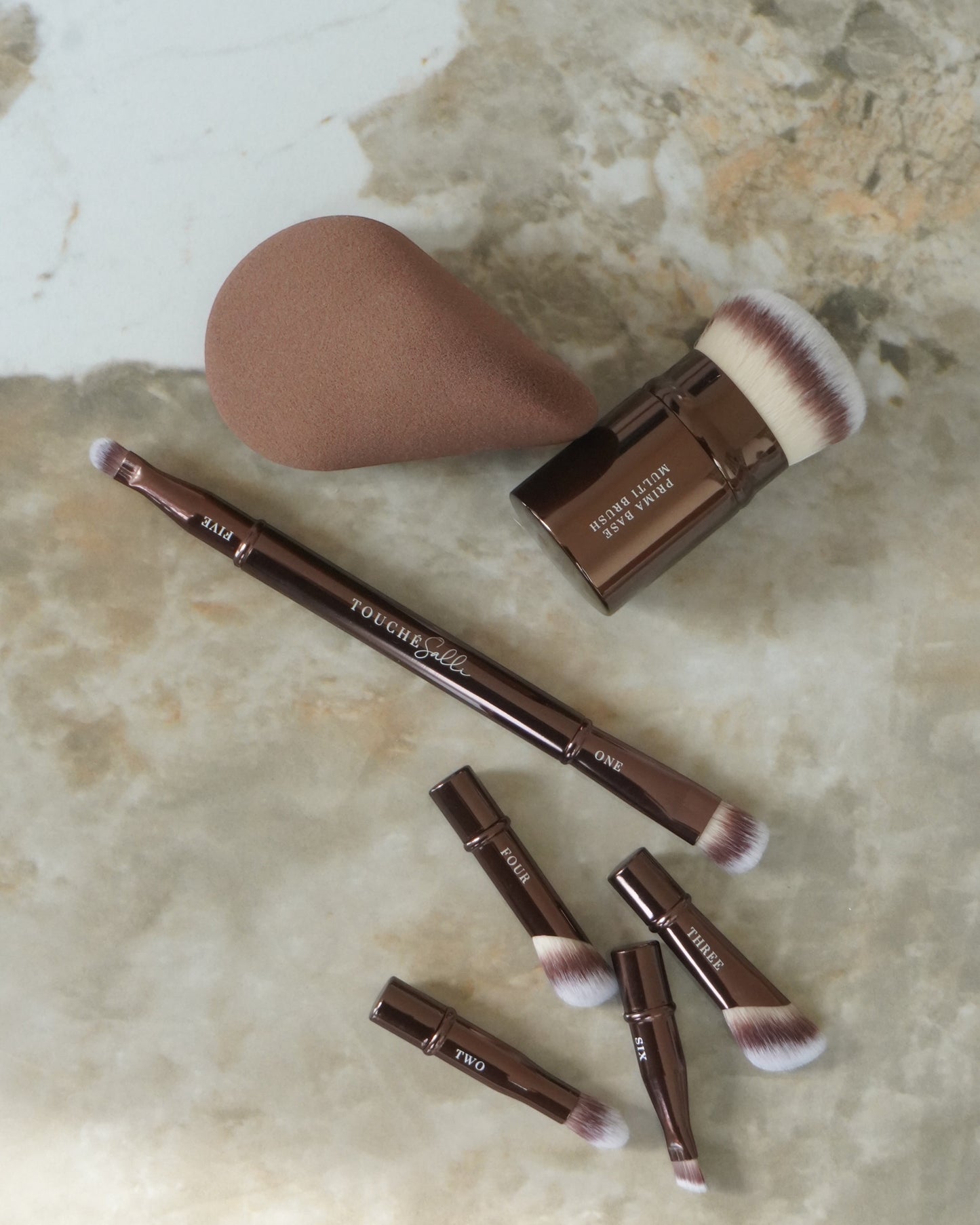 Touché Salli Ellipsa Soft Makeup Sponge i brun, ergonomisk formet til præcis påføring af makeup. Blød og hudvenlig.