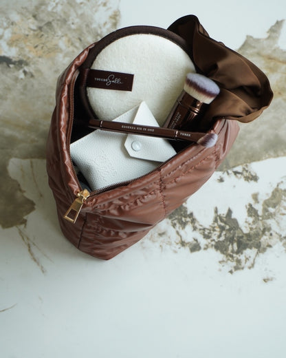 Touché Salli Espresso Quilted Case er en stor kosmetiktaske i mørkebrun med quiltet struktur og gylden lynlås. Rummelig til beauty-essentials.