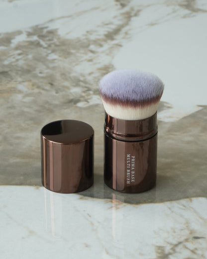 Touché Salli Prima Base Multi Brush, en udtrækkelig kabuki-børste med brune metaldele og bløde, lyse syntetiske hår.